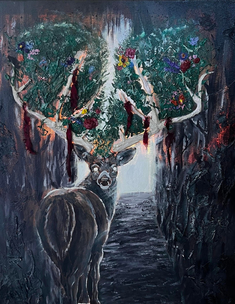 A square canvas painting depicting a dark deer with large antlers standing in a shadowy forest path, photographed leaning against a light-colored surface with studio lighting equipment visible around it.