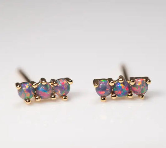 Pair of opal stud earrings with gold setting on a light gray background