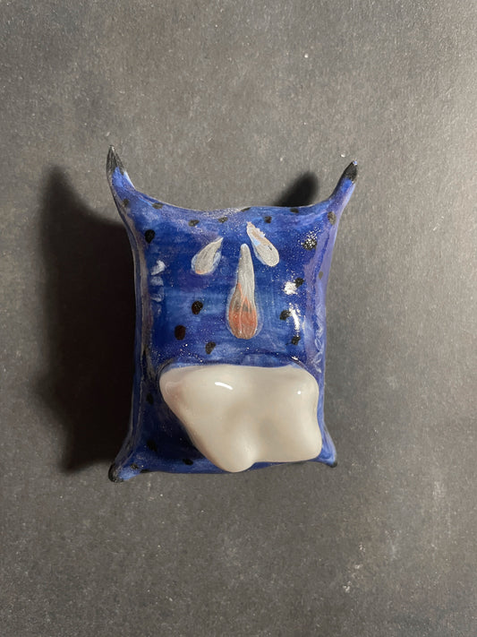 Ceramic wall hook with blue and white design on a gray background