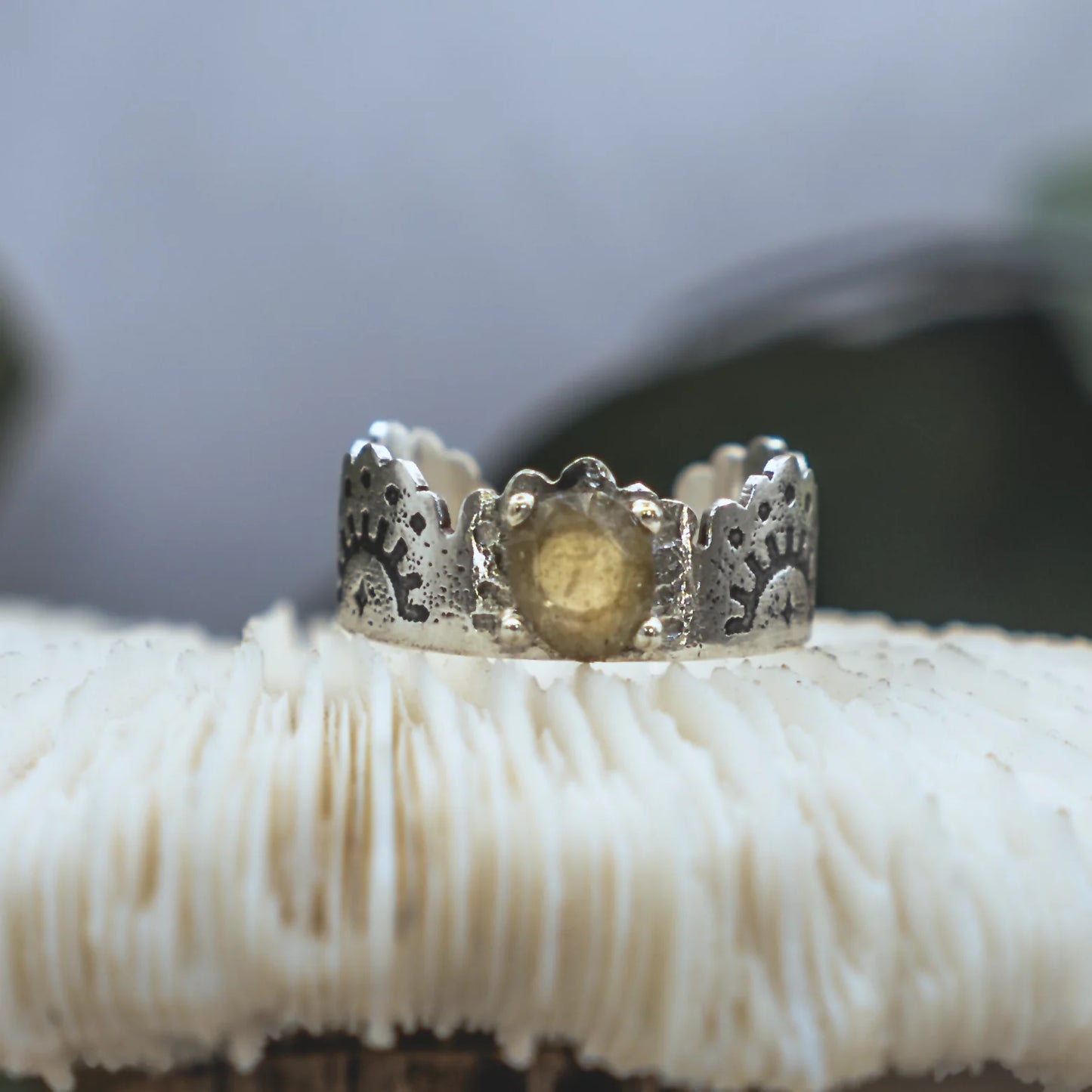 Silver ring with textured design on a white mushroom