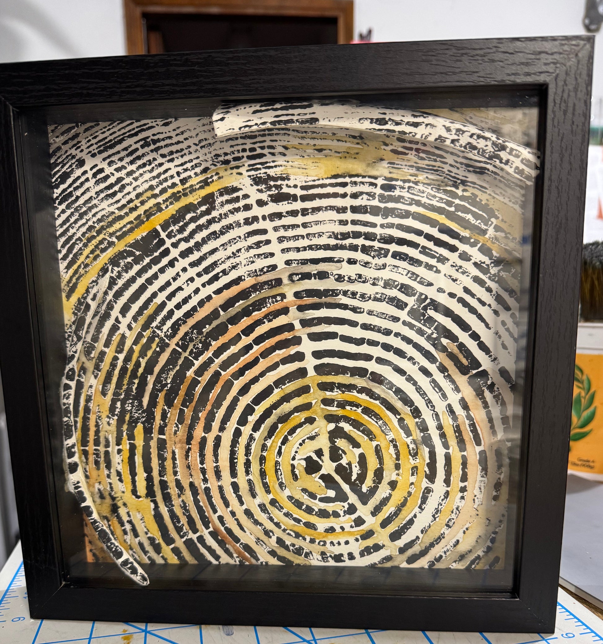 Framed artwork with concentric circular pattern on a grid background