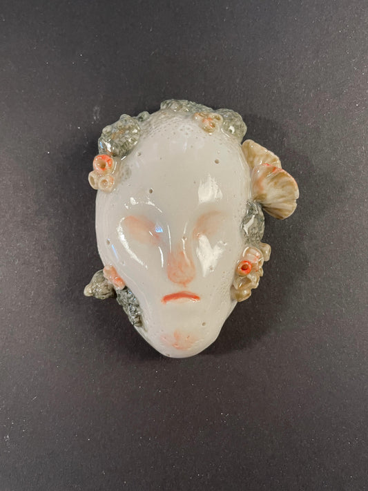 Decorative mask with floral details on a dark background