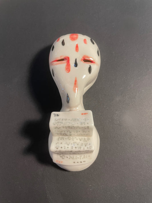 Ceramic art with face design on a dark gray background