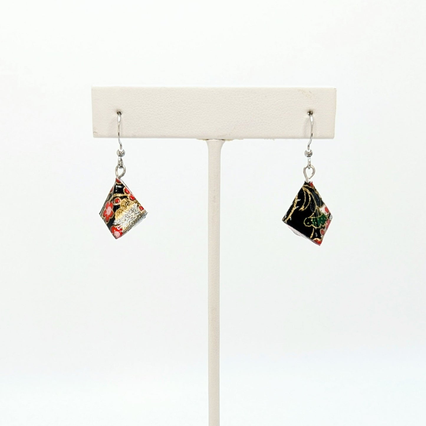 Pair of earrings on a white stand against a white background