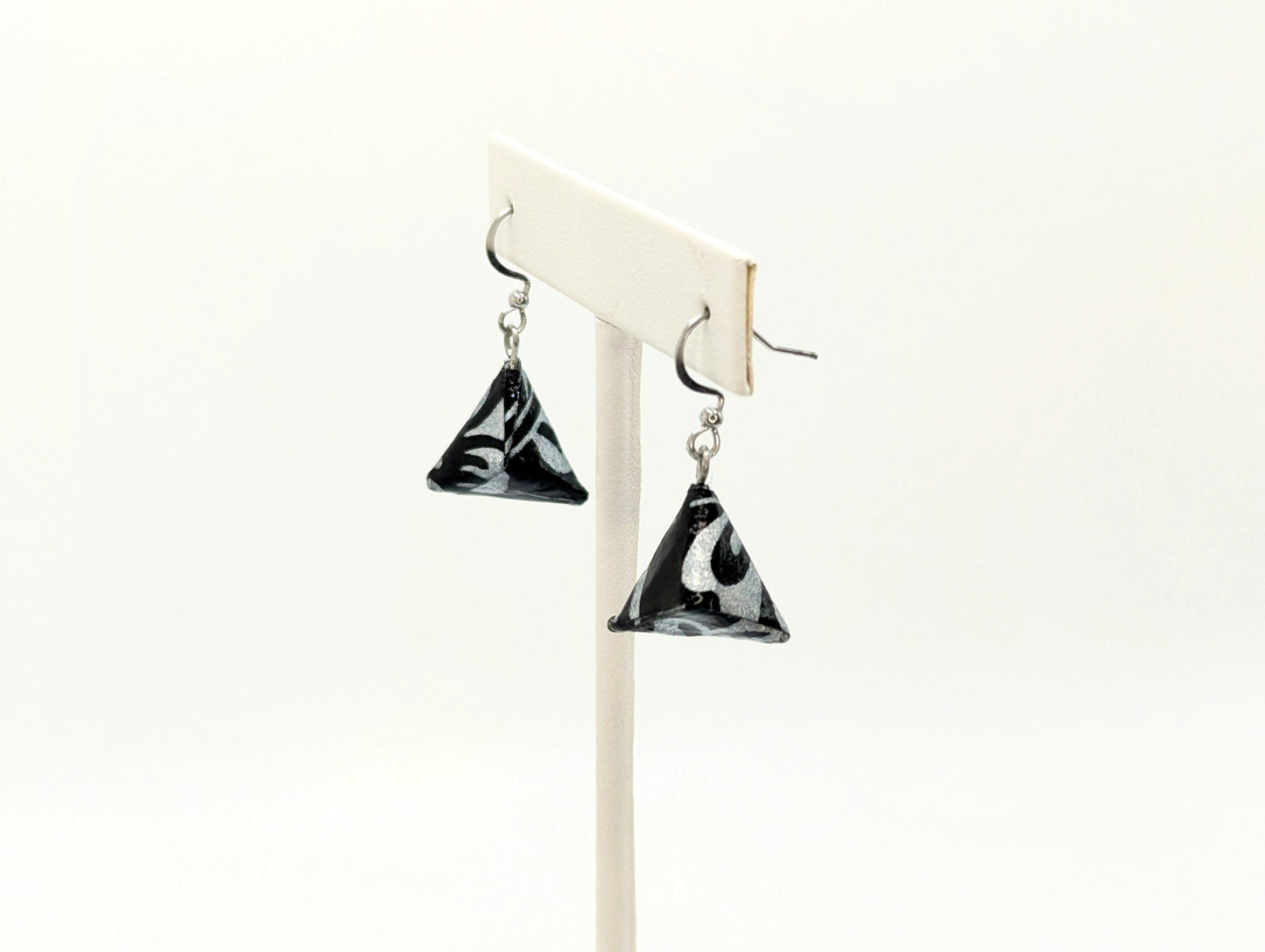 Black and white triangle-shaped earrings on a white background