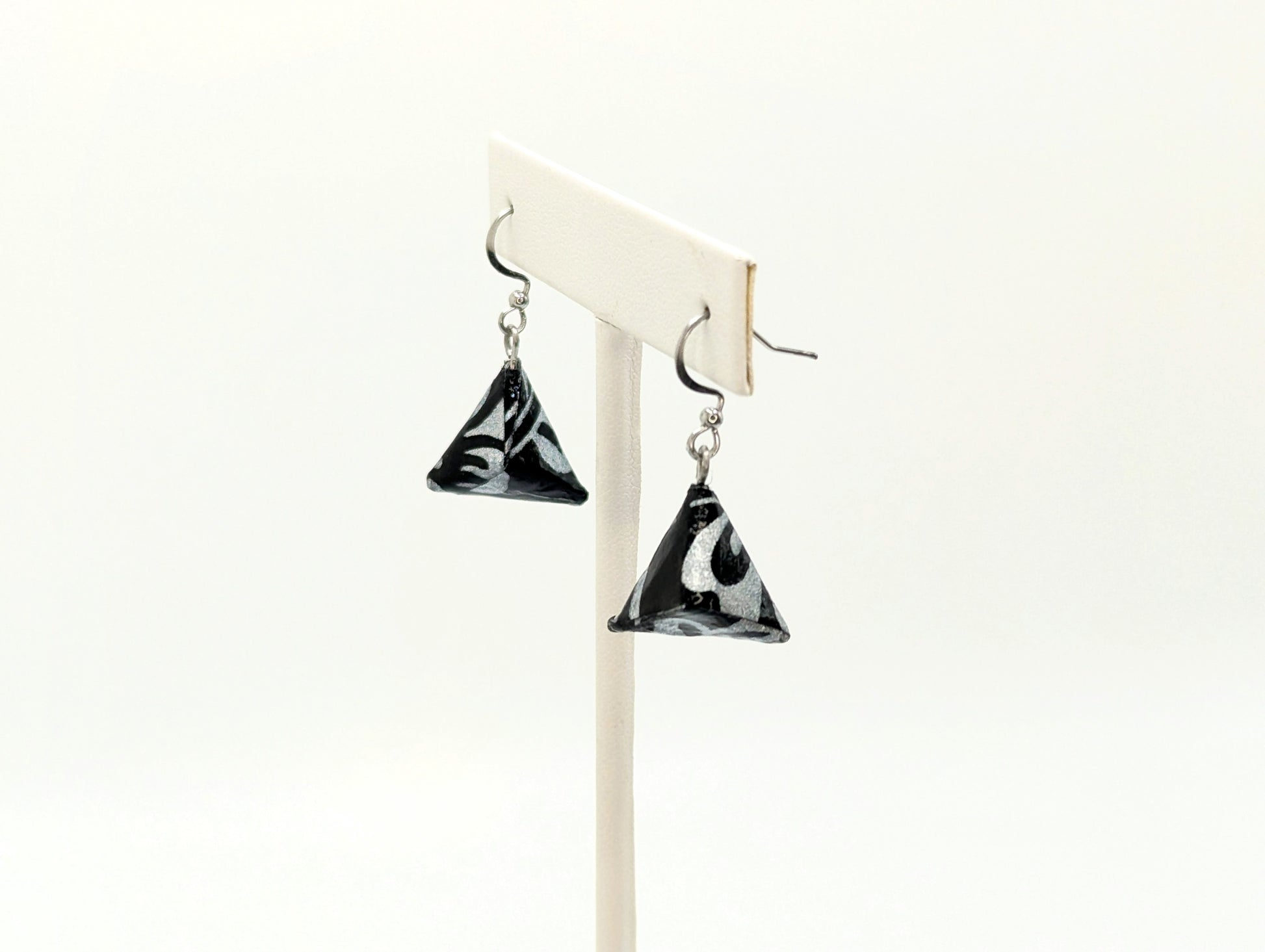 Black and white triangle-shaped earrings on a white background