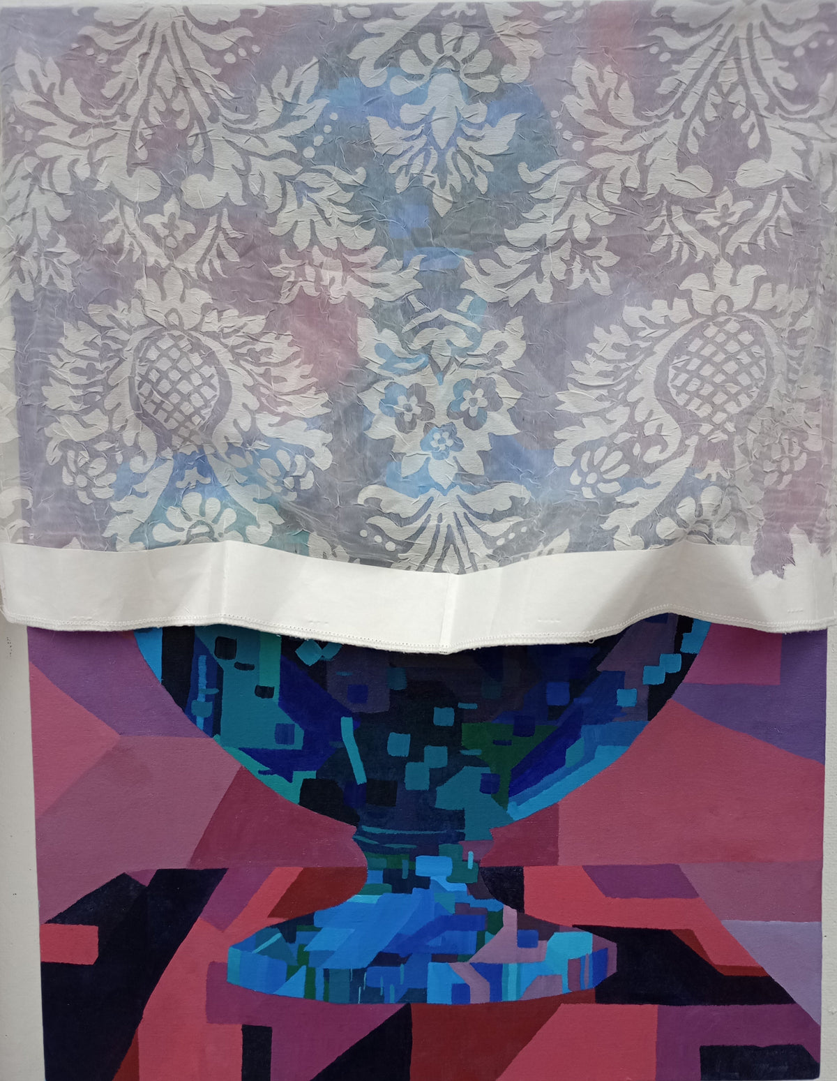 A square textile or fabric panel with a split design: the top half shows a pale blue and lavender damask floral pattern, while the bottom half features a colorful abstract geometric bowl motif in blue, purple, pink, and black. The fabric is photographed hanging against a white wall, with other textile samples partially visible at the edges.