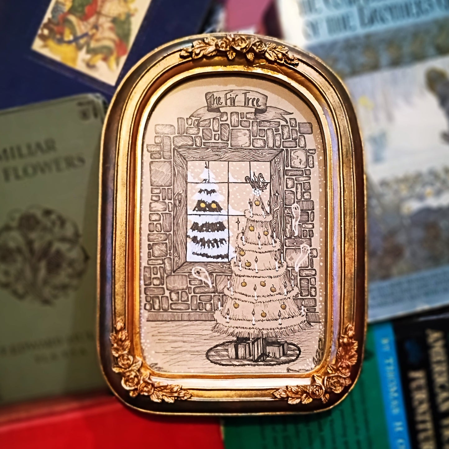 Decorative gold frame with intricate design on a stack of books