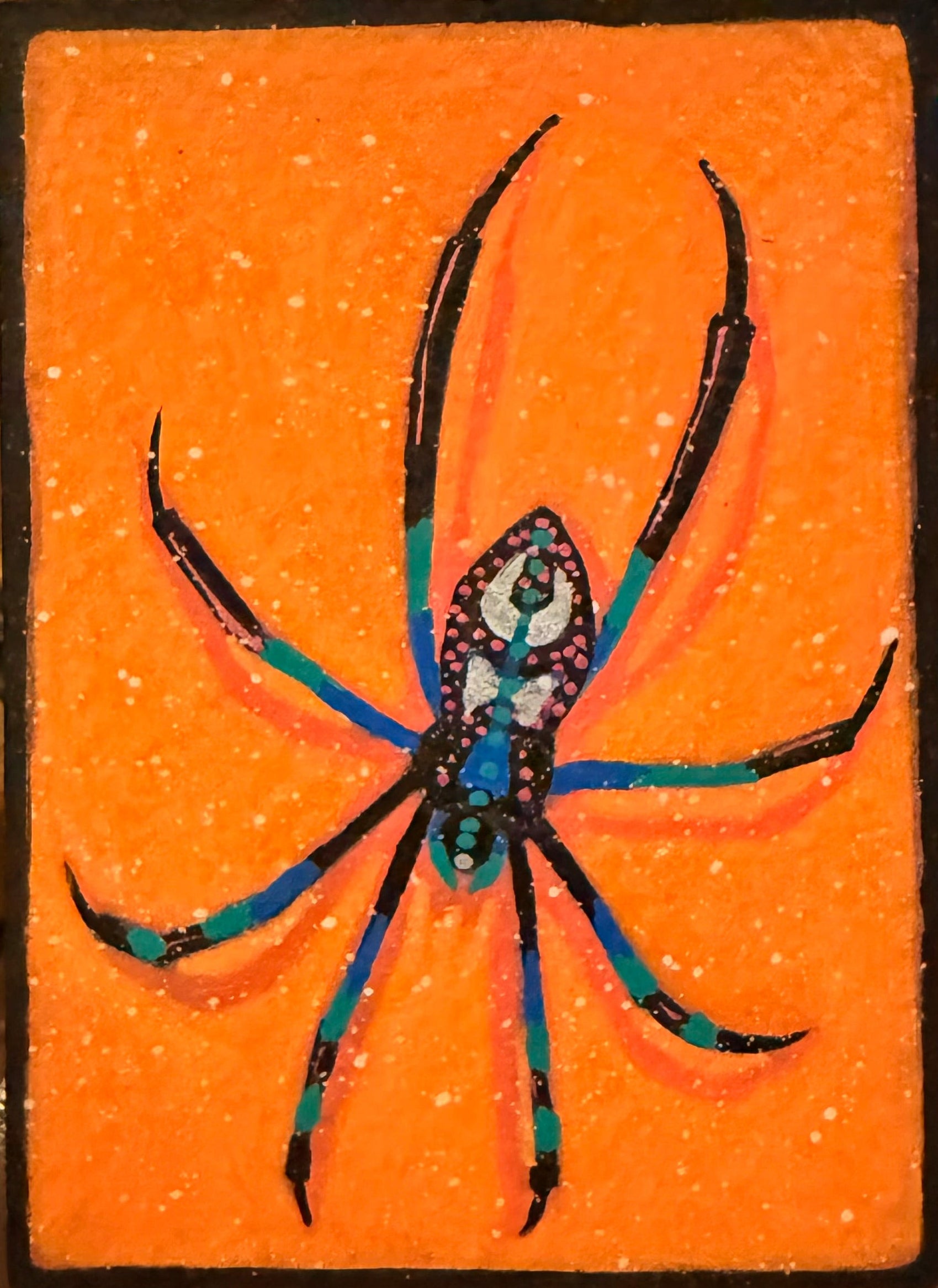 Decorative item with a spider design on an orange background