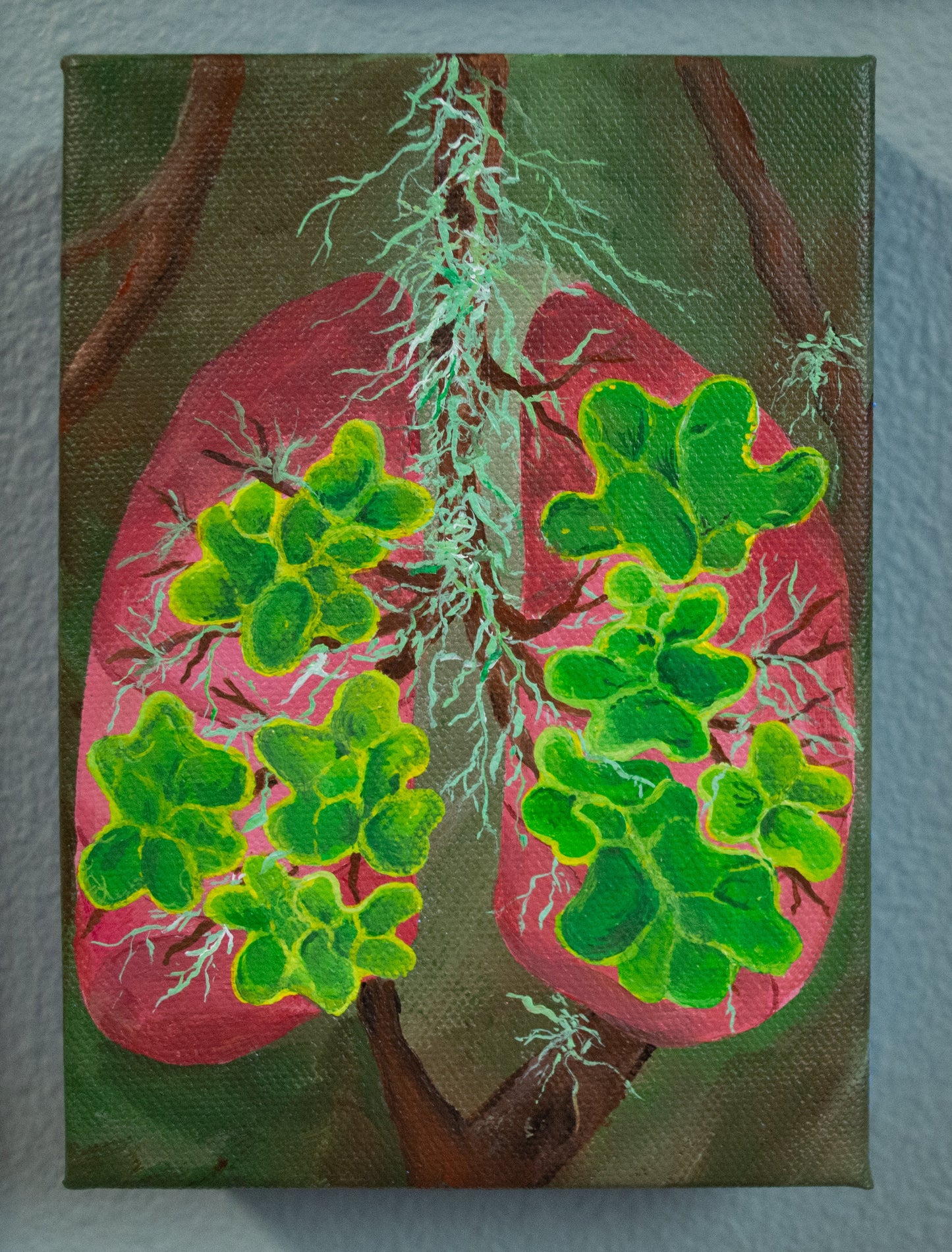 Artistic depiction of lungs with green leaves on a textured wall background